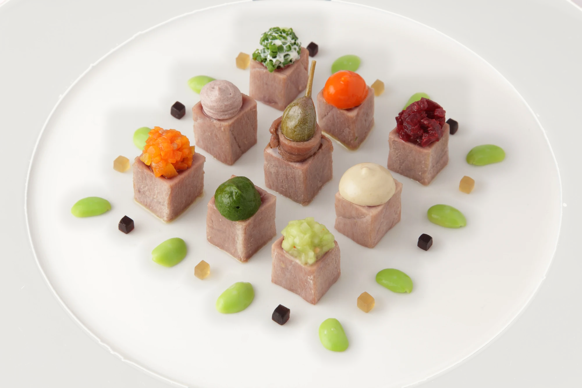 A closer original photograph of nine individually garnished bites